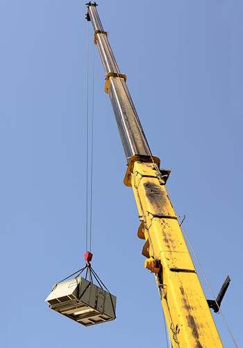 Commercial air unit being lifted onto roof of a commercial manufacturing building. AEM Mechanical Services, Inc.